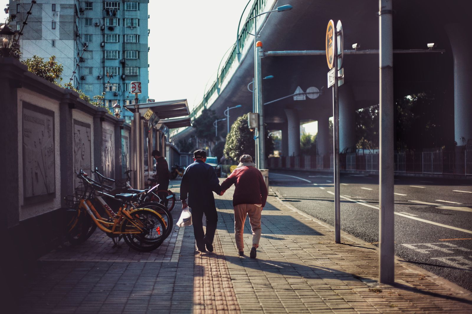 一对退休夫妻在城市街区牵手散步